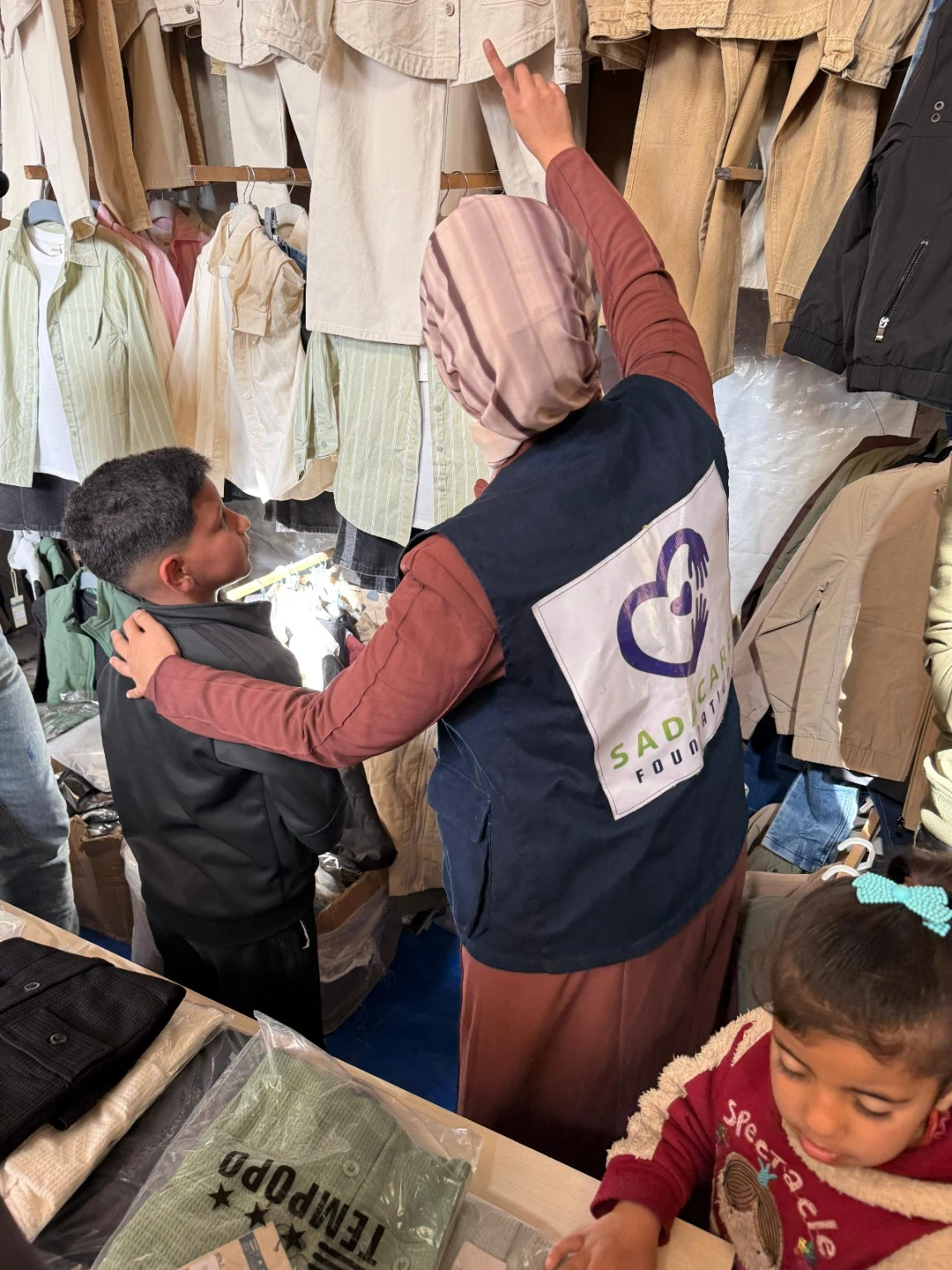 Une bénévole SADACARE accompagne un enfant dans le choix de vêtements